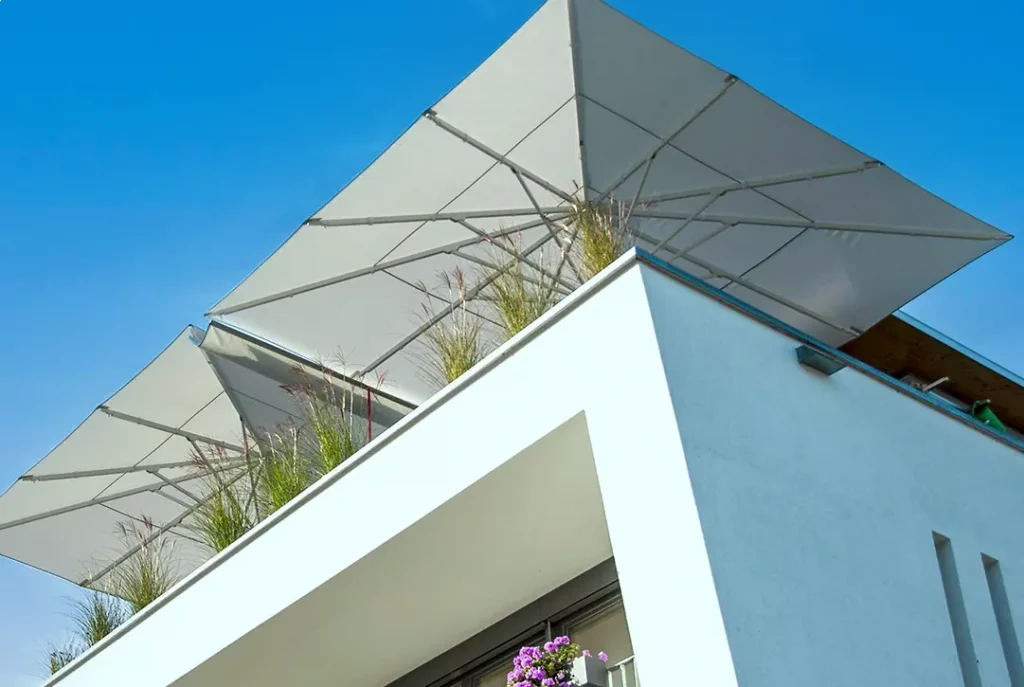 Ein Balkon aus der Froschperspektive mit 2 Gastroschirmen